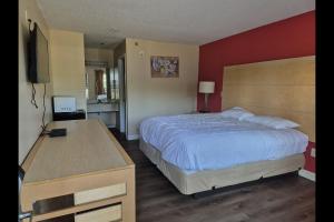 a bedroom with a bed and a desk and a television at General Bragg Inn & Suites Chickamauga in Chickamauga +36 photos