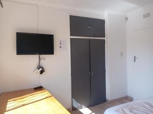 a bedroom with a tv on the wall and a bed at TRIANGLE STARS Guest House in Kempton Park +12 photos