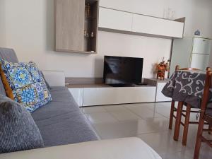 カーポ・リッツートにあるCASA VACANZA SUL MAREのソファと薄型テレビのあるリビングルーム