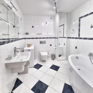 a white bathroom with a tub sink and a toilet at Izabelin Apartment in Swarzędz +16 photos