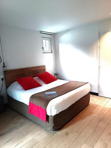 a bedroom with a large bed with a wooden floor at Hôtel Ar Iniz in Saint Malo