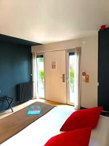 a bedroom with a large bed with red pillows at Hôtel Ar Iniz in Saint Malo