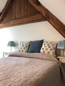 a bedroom with a large bed with two lamps on tables at Stunning stone cottage on Bath's doorstep in Box