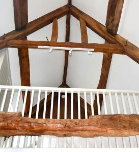 a ceiling with wooden beams and a white crib at Stunning stone cottage on Bath's doorstep in Box