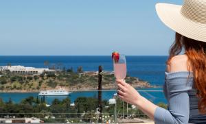 una mujer sosteniendo una copa de vino rosado en Evilion Home 2, en Agios Nikolaos