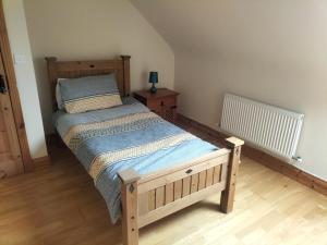 a bedroom with a wooden bed and a wooden floor at Lomonagh Lodge Portmagee in Lateeve