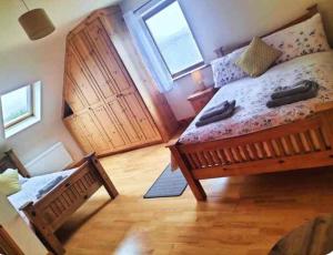 a bedroom with a large wooden bed and two windows at Lomonagh Lodge Portmagee in Lateeve +14 photos