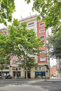 a tall building with a tree in front of it at BBarcelona Sant Pau Flat in Barcelona