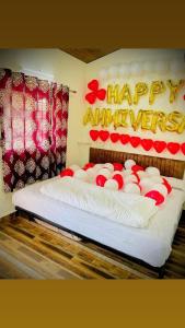 a bedroom with a happy anniversary sign on a bed at Hotel Krushnai Athvan Farm House in Khamshet