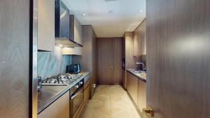 a kitchen with wooden cabinets and a stove top oven at Vacationer Holiday Homes I Opulent 2 Bedroom I Sea View I Beach Access l FIVE Palm in Dubai