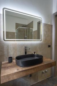 a bathroom with a black sink and a mirror at Aurelia Garden Suite in Rome