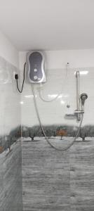 a shower with a hose attached to a wall at Sigiriya Mirror wall Guest house in Sigiriya