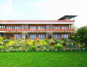 a house with a lot of potted plants in the yard at Chitralekha Boutique Resort in Rājpur