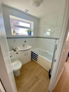 a bathroom with a toilet and a sink and a tub at Seagulls Rest in Isle of Wight +25 photos