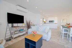 ein Wohnzimmer mit Couch und Flachbildfernseher in der Unterkunft Rua do Paraiso 15 Oceanview Carvoeiro Retreat in Carvoeiro