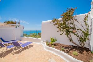 eine Terrasse mit Stühlen und Blick auf das Meer in der Unterkunft Rua do Paraiso 15 Oceanview Carvoeiro Retreat in Carvoeiro