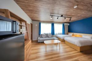 a hotel room with two beds and a couch at 西裏ステイ なか富士 Nishiura stay Naka Fuji in Fujiyoshida