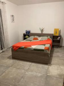 a bedroom with a bed with an orange blanket at Chambre d'hôte, SdB & accès privé, piscine, jardin in Gémenos