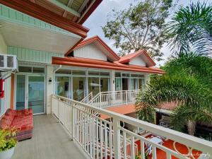 a porch of a house with a red couch at Carms Villa Resort in Kidapawan