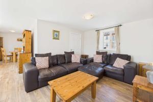 un salon avec un canapé en cuir et une table dans l'établissement Host & Stay - Easton Meadows Holiday Cottage, à Boynton 13 autres photos