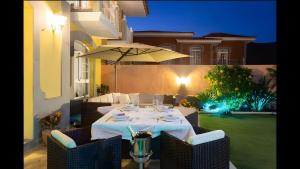 un tavolo con sedie e un ombrellone in un patio di Villa Tenerife Luxe ad Adeje