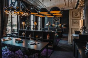 Una habitación con una mesa, sillas y lámparas. en Canal House, en Ámsterdam