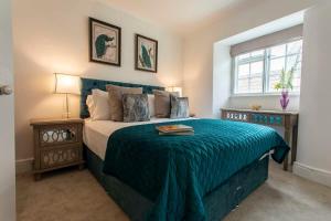 a bedroom with a large bed with a blue blanket at Central, beautiful home - with parking in Bradford on Avon