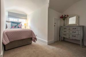 a bedroom with a bed and a dresser and a mirror at Central, beautiful home - with parking in Bradford on Avon