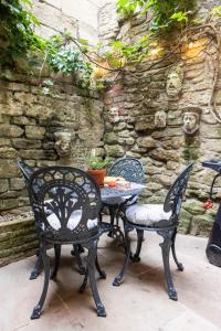 a table and chairs sitting next to a stone wall at Central, beautiful home - with parking in Bradford on Avon