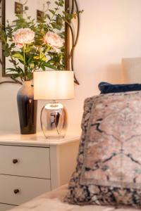 a bedroom with a table with a lamp and a vase with flowers at Central, beautiful home - with parking in Bradford on Avon