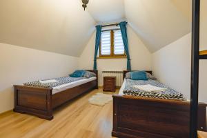 two beds in a room with a window at Dom na Górce in Groń
