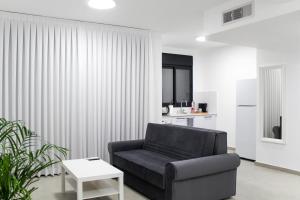 埃拉特Luxury Suite Apartment #57 By Hashdera Eilat的客厅配有黑椅子和桌子
