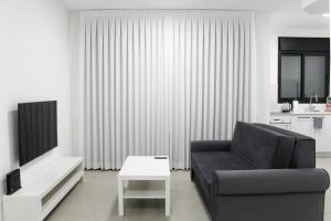 埃拉特Luxury Suite Apartment #57 By Hashdera Eilat的客厅里有一张黑色沙发和一张桌子