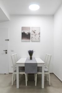 埃拉特Luxury Suite Apartment #57 By Hashdera Eilat的白色的用餐室配有白色的桌椅