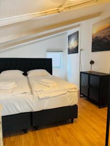 a bedroom with a large bed with a black headboard at Het zandhuisje 84 in Noordwijk aan Zee