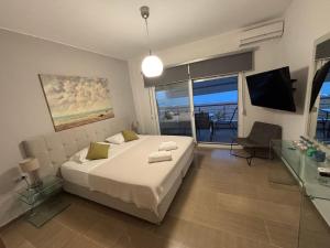 a bedroom with a bed and a view of the ocean at Korelis Apartments in Ayia anna