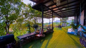 a pavilion with benches and trees in a park at Bonkao Sawan Café in Ban Khlot