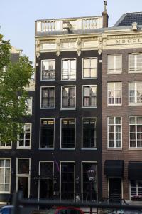 Un gran edificio negro con ventanas en una calle de la ciudad. en Canal House, en Ámsterdam