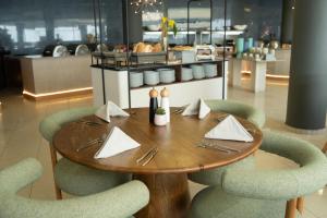 a wooden table and chairs with napkins on it at Trypiti Resort Blue Dream Palace and Hive Water Park in Limenaria