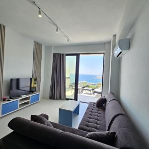 ein Wohnzimmer mit Couch und Blick aufs Meer in der Unterkunft Blue Horizon And Seaside Serenity in Sarandë