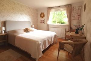 a bedroom with a bed and a window and a table at TheGilgahouse Familyroom! in Nakskov