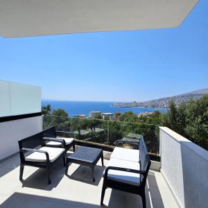 ein Balkon mit Stühlen und Blick auf das Meer in der Unterkunft Blue Horizon And Seaside Serenity in Sarandë