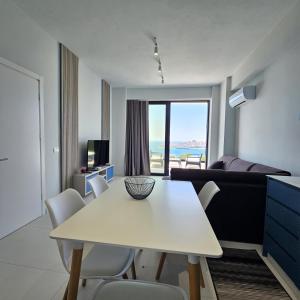 ein Wohnzimmer mit einem weißen Tisch und Stühlen in der Unterkunft Blue Horizon And Seaside Serenity in Sarandë + 21 Fotos