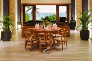 a dining room with a table and chairs and the ocean at Villa Nanas Balian Beach in Balian