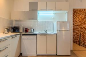 a kitchen with white cabinets and a refrigerator at Old Town - Superb apartment in rue Esquermoise ! in Lille +17 photos
