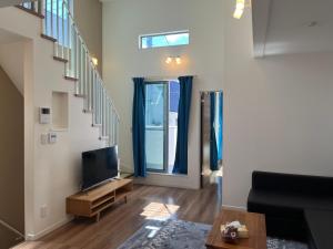 a living room with a tv and a staircase at 東京都新宿区渋谷区吹き抜けりリビング in Tokyo
