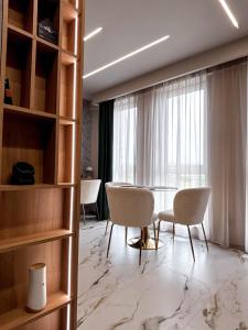 Una habitación con sillas y una mesa y una ventana. en Airport SkyLuxe Luxury Residence, en Someşeni