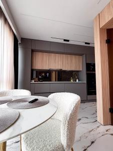 a living room with a white table and chairs at Airport SkyLuxe Luxury Residence - Private Parking in Cluj-Napoca +25 photos