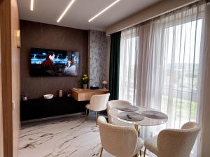 a living room with a tv and a table and chairs at Airport SkyLuxe Luxury Residence - Private Parking in Cluj-Napoca