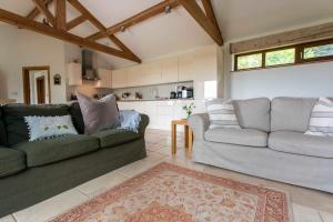 a living room with two couches and a kitchen at Beautiful Box Hill Lodge in Box
